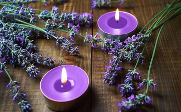 Lavender flowers and purple candles on wooden table for aromatherapy and relaxation