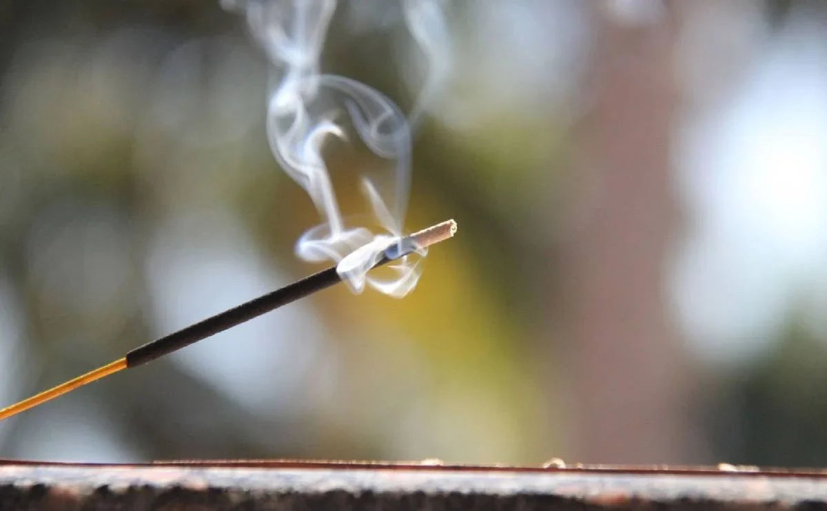 Burning incense stick with rising smoke, focus and meditation concept.